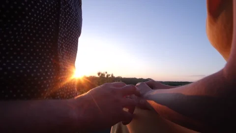 Warm sunlight caressing man's hand tenderly touching woman at sunset. Stock Footage 313815311