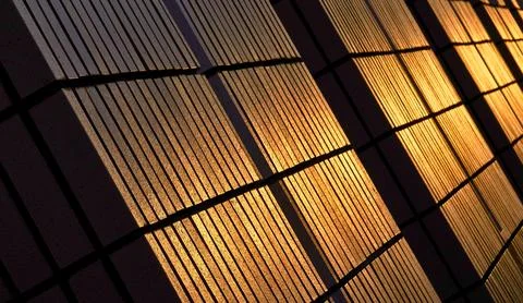 Warm sunlight creates dramatic shadows on a textured surface Stock Photos