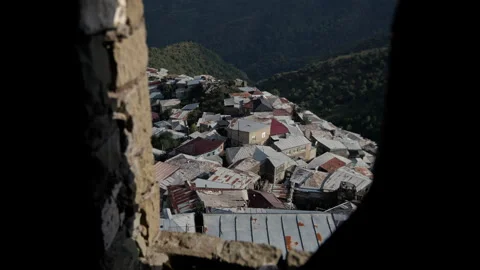 Warm sunlight filtering through cracked stone window, revealing stone-roofed Stock-Footage 297615355