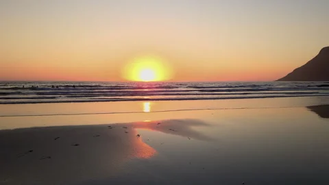 Warm sunlight illuminates the tranquil scene of wet sandy beach in Lofoten Stock Footage 297119553