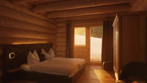 Warm sunlight illuminating a cozy, rustic log cabin bedroom with a view of a Stock-Footage 335786187