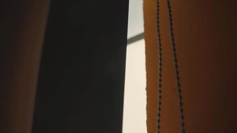Warm sunlight shining through slowly moving black out roller blinds Vídeo Stock 316069000