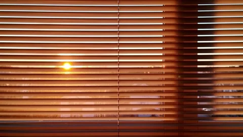 Warm Sunlight Streaming Through Window Blinds at Sunrise in Cozy Home Interior Video stock 315623011