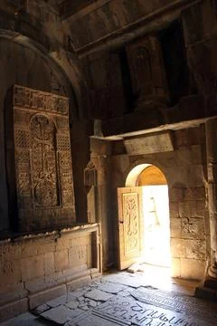 Warm sunlight streams through the open doors of an ancient stone church, Stock Photos