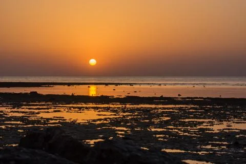 Warm sunrise with reflection on the beach Stock Photos