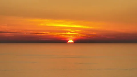 Warm Sunset Colors Paint the Sky as the Sun Meets the Ocean Line Stock Footage 312709943