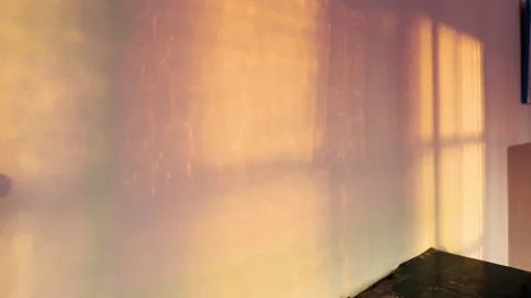 Warm sunset light reflections and window frame shadows on empty room wall Stock Footage 336533745