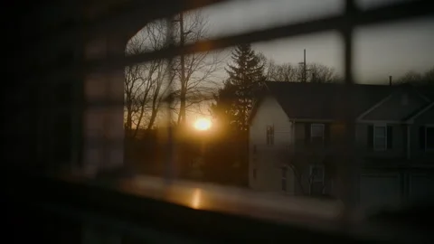 Warm sunset light shines through partially closed window jalousie blinds Stock Footage 322803333