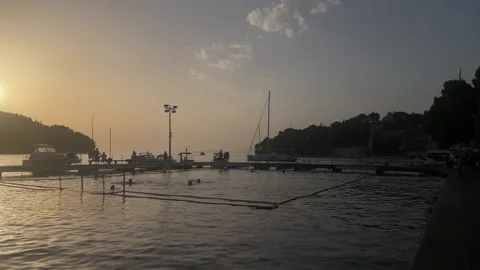 Warm sunset over the waterfront and calm Adriatic water near Cavtat Stock Footage 344391747