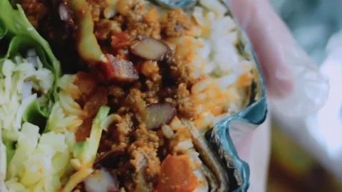 Warm tabletop view: foil-wrapped burrito cross section Stock Footage 342168446