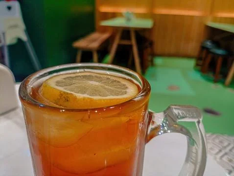 A Warm tea with lemon slice in clear glass mug in restaurant Stock Photos
