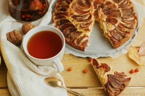 Warm tea in stylish cup on rustic table with freshly baked apple pie with c.. Stock Photos