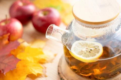 Warm tea in a teapot on the table with apples, autumn still life Stock Photos