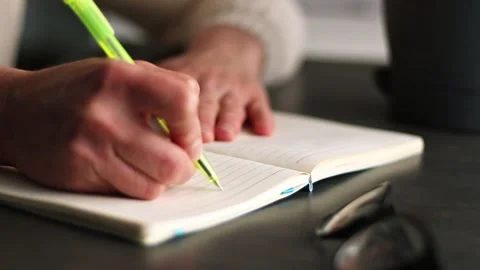 Warm toned image of hand writing personal thoughts in diary. Blurred background Stock Footage 307751857