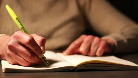 Warm toned image of hand writing personal thoughts in diary. Blurred background Stock Footage 307751864