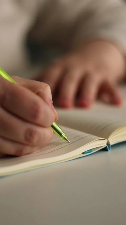 Warm toned image of hand writing personal thoughts in diary. Blurred background Stock Footage 310267356