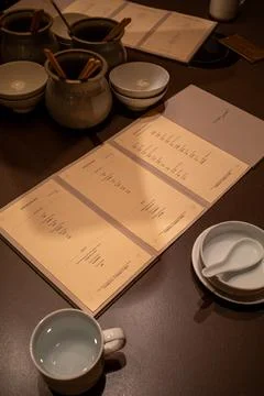 Warm-toned table holds ceramic bowls and cups Stock Photos