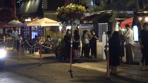 Warm ummer night with people walking and restaurant patios open post COVID 19 Stock Footage 158472469