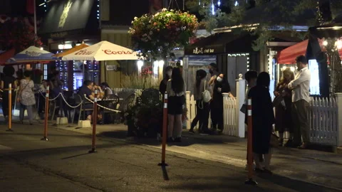 Warm ummer night with people walking and restaurant patios open post COVID 19 Stock Footage 158473216