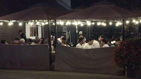 Warm ummer night with people walking and restaurant patios open post COVID 19 Vídeo Stock 158481741