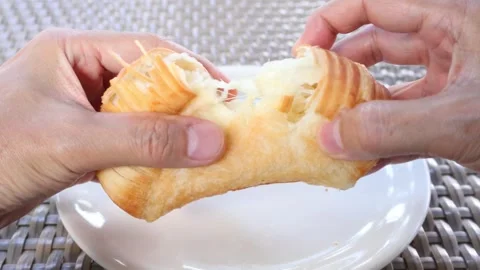 Warm viennoiserie pastry pulling apart showing buttery laminated layers Stock Footage 338294641