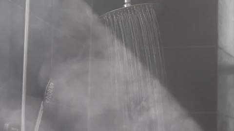 Warm water streams make hot vapor in grey tiled shower Stock Footage 162936720