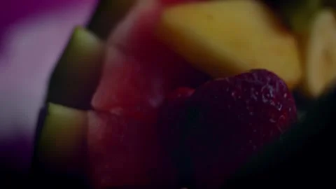 Warm watermelon handle arching over mixed fruit in top view, 4K Vidéo 341115005