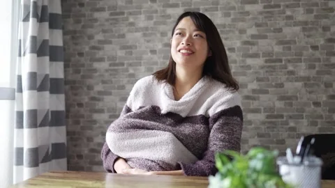 In a warm winter room, a 6-month-old Japanese baby girl wearing fluffy clothes Video stock 296932155