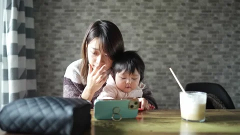 In a warm winter room, a 6-month-old Japanese baby girl wearing fluffy clothes Video stock 296947152