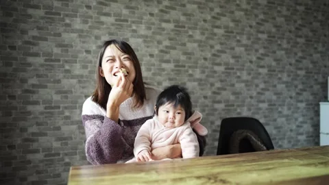 In a warm winter room, a 6-month-old Japanese baby girl wearing fluffy clothes Vídeos de archivo 296947730