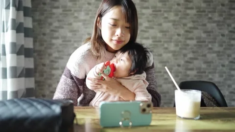 In a warm winter room, a 6-month-old Japanese baby girl wearing fluffy clothes 動画素材 296983535