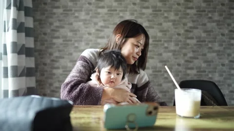In a warm winter room, a 6-month-old Japanese baby girl wearing fluffy clothes Video stock 296984523