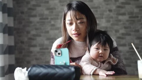 In a warm winter room, a 6-month-old Japanese baby girl wearing fluffy clothes Stock Footage 296986266