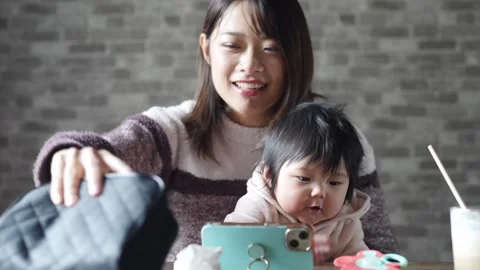 In a warm winter room, a 6-month-old Japanese baby girl wearing fluffy clothes Video stock 296986737