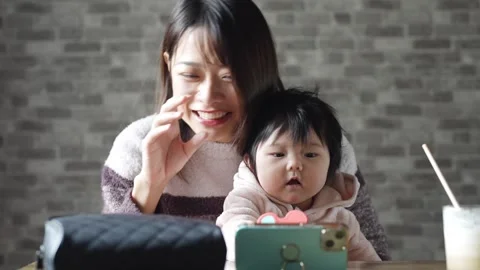 In a warm winter room, a 6-month-old Japanese baby girl wearing fluffy clothes Stock Footage 296987553