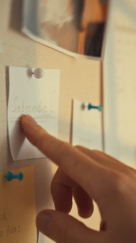 In a warm workspace lit by natural light a hand reaches for a handwritten no Stock Footage 331794596