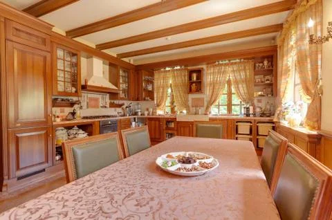 Warm yellow clean, kitchen interior with stainless steel appliances in a luxury 写真素材
