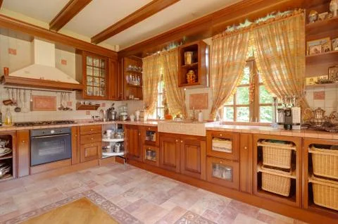 Warm yellow clean, kitchen interior with stainless steel appliances in a luxury 写真素材