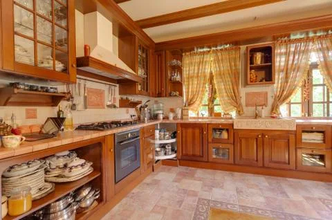 Warm yellow clean, kitchen interior with stainless steel appliances in a luxury Stock Photos