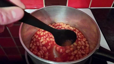 Warming baked beans on the hob Video stock 258071739