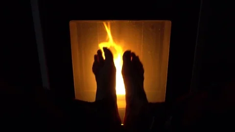 Warming bare feet in front of fire | Stock Video | Pond5