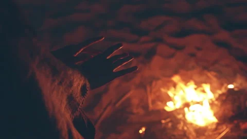 Warming hands by bonfire on the beach. Faceless closeup shot. Spend free time in Stock Footage 251898050