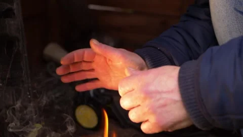 Warming hands by the glow of a fire Video stock 154263866
