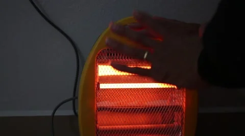 Warming up hands by heater Stock Footage 46459000