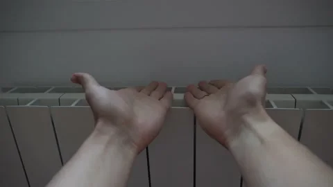 Warming hands up on heating radiator. Cold winter. No gas concept Video stock 221028591