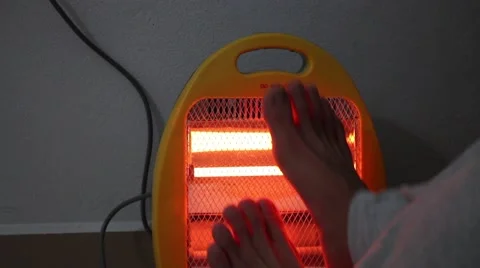 Warming up legs by heater Stock Footage 46460452