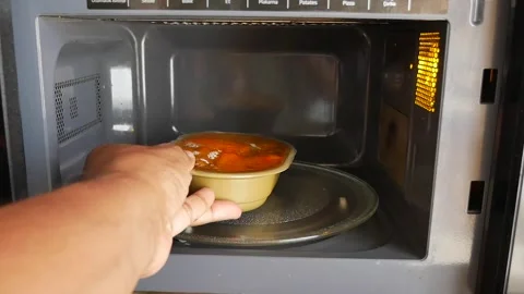 Warming meals using the microwave oven for quick and easy cooking Stock Footage 345621667
