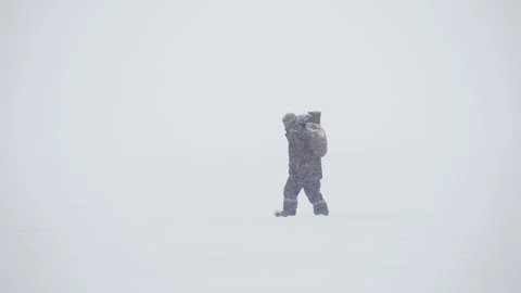 A warmly dressed man walks in a heavy snowfall. It is almost invisible because Stock Footage 157672964
