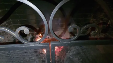 A warmly lit fireplace, with burning logs creating a comforting and calm ambi Stock Footage 314660929