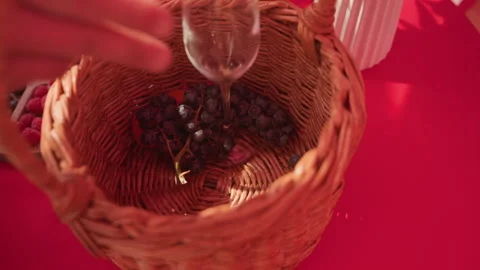 Warmly lit scene featuring hands arranging grapes and pouring wine, Cinematic Stock Footage 329455627